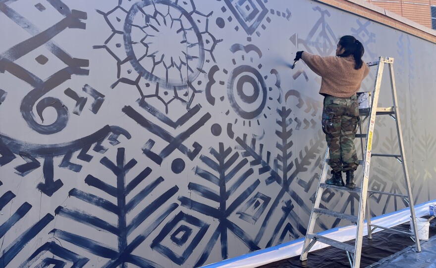 Artist Venazir Martinez works on a mural near Old Dominion University's Chartway Arena. Martinez is creating a piece that celebrates Filipino and Norfolk's history. She will give a talk on Thursday, Oct. 30 about her work.
