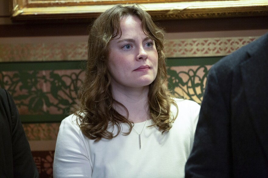 A woman stands in an ornate room
