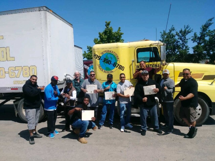 FreeWorld Participants gather for a photo in front of a truck.
