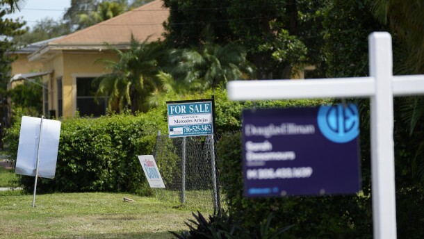 FILE - Realty signs indicating homes for sale hang in front of properties in the Coconut Grove neighborhood of Miami. (AP Photo/Rebecca Blackwell)