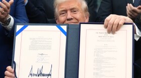 President Donald Trump displays the signed the funding bill to reopen the government, in the Oval Office of the White House, Wednesday, Nov. 12, 2025, in Washington. (AP Photo/Jacquelyn Martin)
