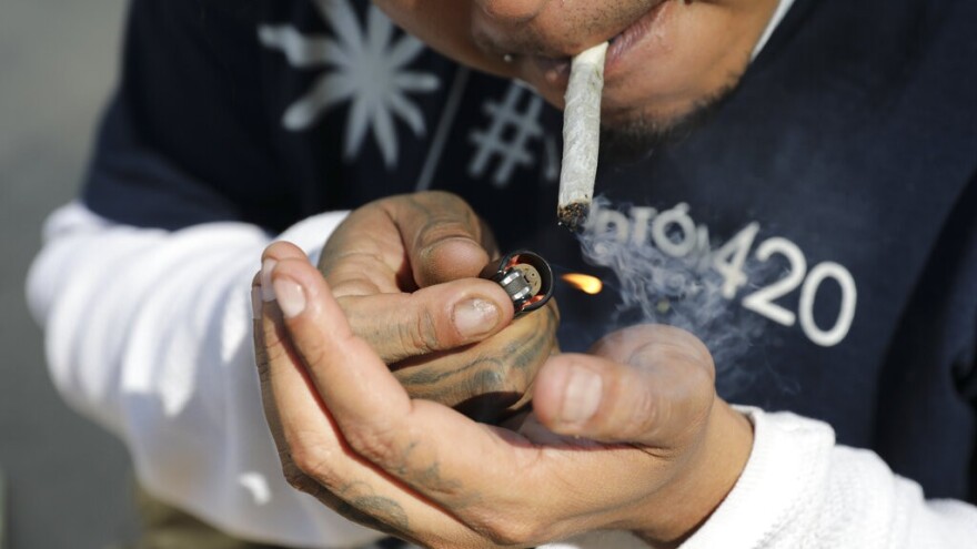 man lights up marijuana joint 