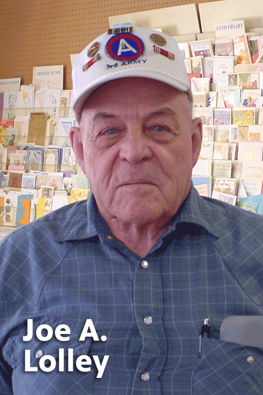 Elderly Joe A Lolley wearing a blue plaid button-up shirt and a baseball cap