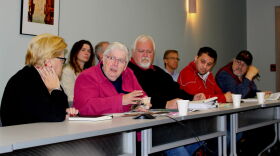 Cindy Perdue-Dolan (L) a field representative with Senator Daines' office looks on as Sister Mary Jo MacDonald shows pictures of the historic Upper Silver Bow Creek corridor. Members of ROCC and Montana's Board of Investments are also pictured.