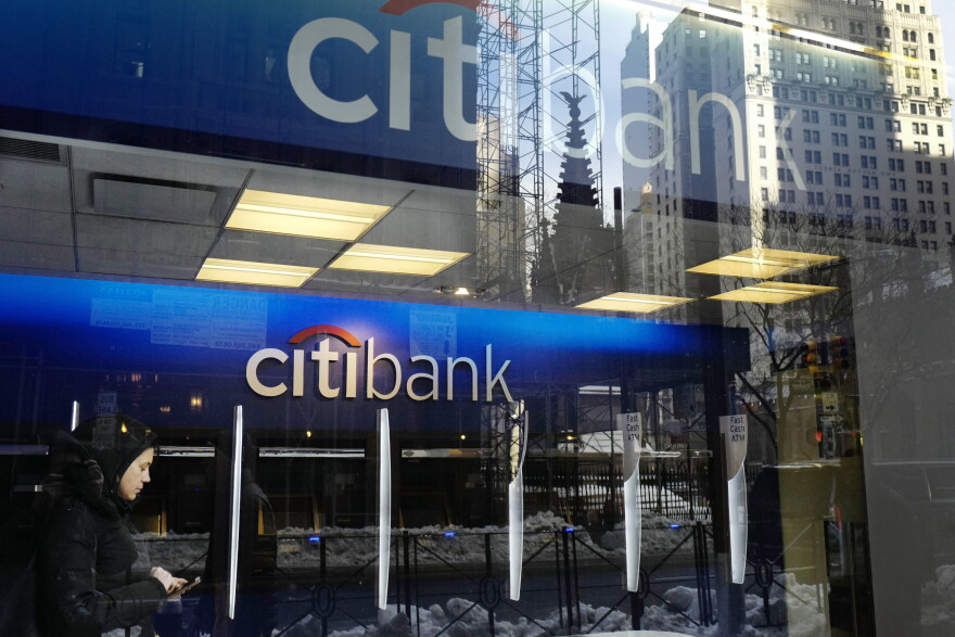A Citibank logo is seen through a window outside a bank branch.