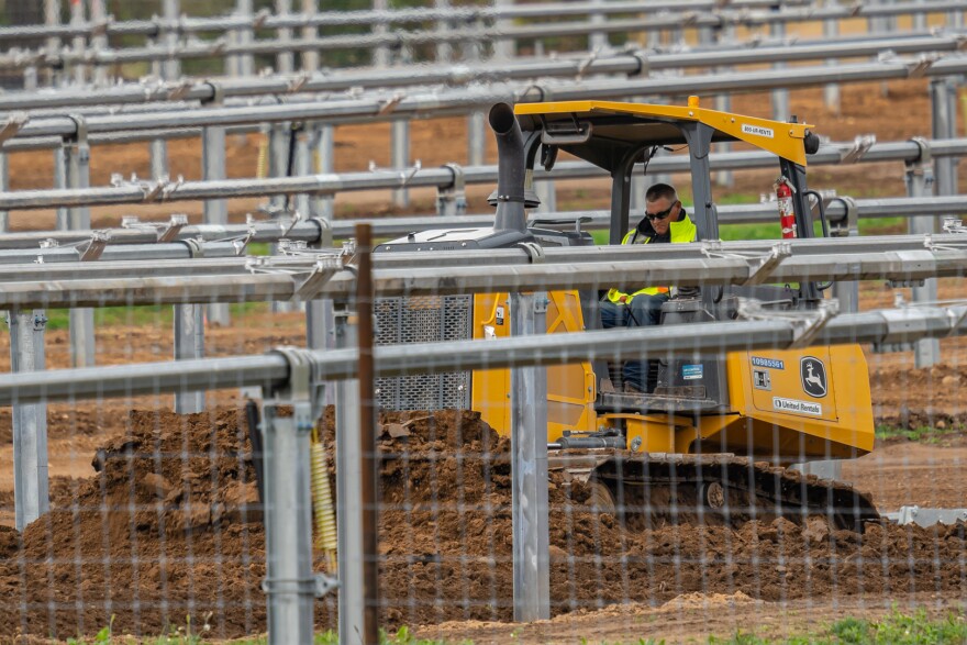 A skid steer moves earth at the Hodag Solar site.