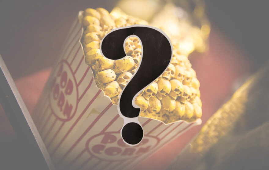 A bucket of movie popcorn, but the popcorn is skulls; a question mark in the foreground