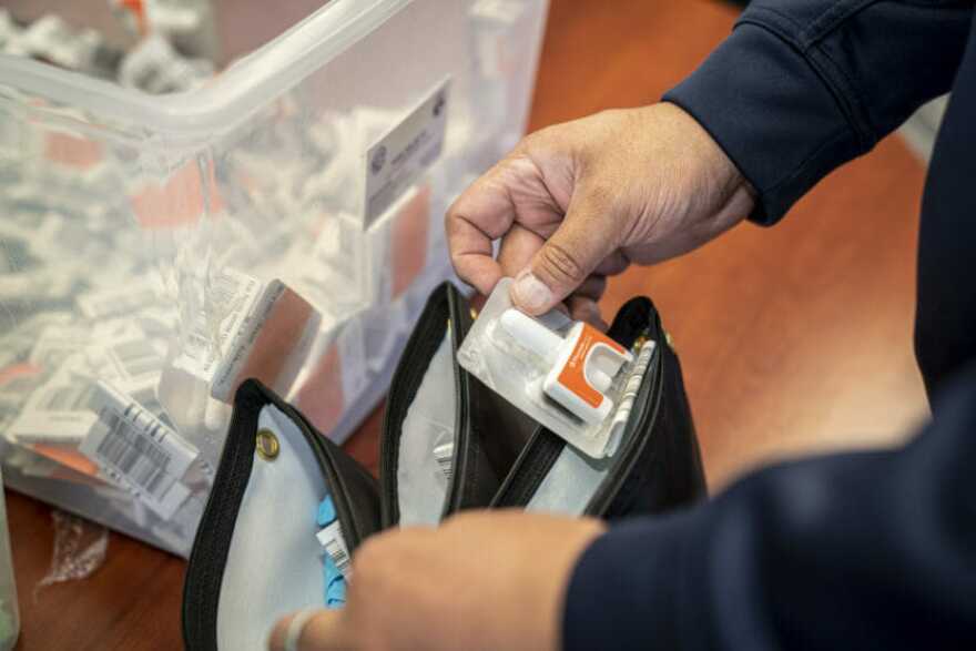 A hand holding naloxone