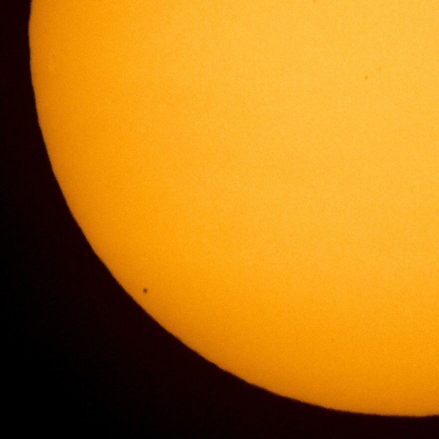The planet Mercury is seen in silhouette, lower left, as it transits across the face of the sun on May 9, 2016. Another transit of Mercury — the last one for 30 years — will take place Monday. [Bill Ingalls / AP]