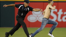 A security person chases a fan who ran onto the field during the fourth inning of a baseball game. Friday, June 24, 2016. (AP Photo/Nam Y. Huh)
