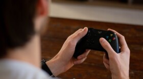 Over the shoulder shot of man holding video game controller