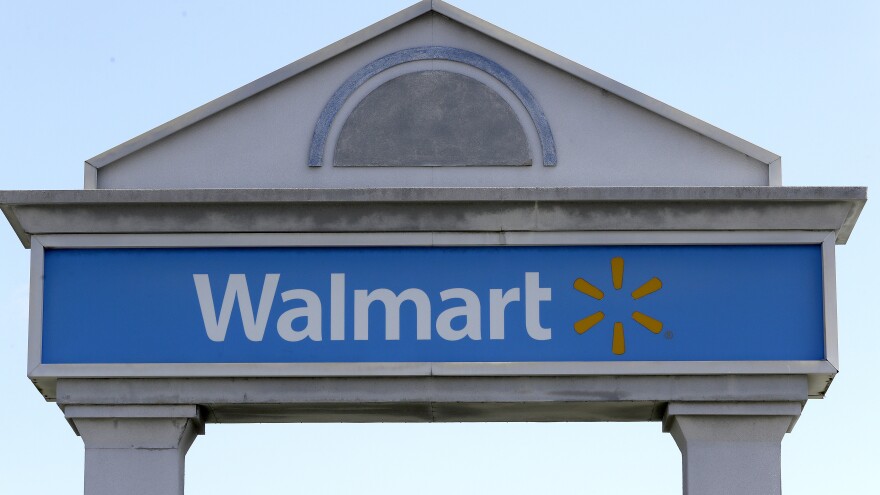 A Walmart logo forms part of a sign outside a Walmart store, Tuesday, Sept. 3, 2019, in Walpole, Mass. Walmart is going back to its folksy hunting heritage and getting rid of anything that's not related to a hunting rifle after a mass shooting this summer.