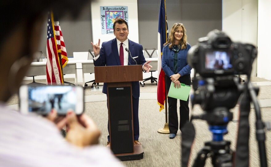 Outgoing AISD Superintendent Paul Cruz gives a Hook'em Horns salute as he speaks during a press conference about his resignation. Cruz is taking a position at UT Austin.