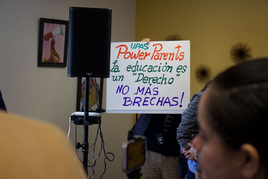 An advocate holds a sign that reads "education is a right, no more gaps."