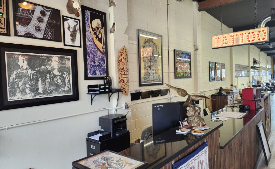 A front desk with pictures and decorations hanging behind it.