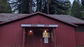 A red one-story building with trees in the background.