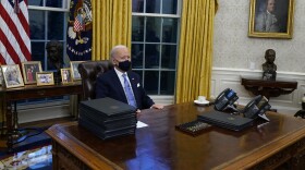 President Joe Biden pauses as he signs his first executive orders in the Oval Office last Jan. 20.