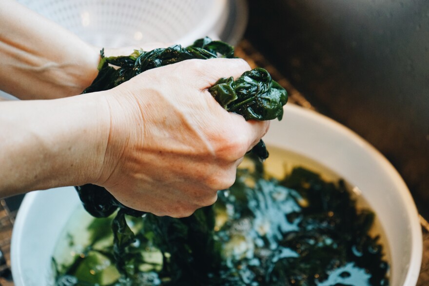 The author's mother washes seaweed to make <em>miyeok-guk (</em>미역국), seaweed soup.