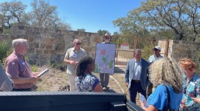 State Rep. Mark Dorazio, R-San Antonio, left, and State Rep. John Lujan, R-San Antonio, fourth from right (in jacket), visit with residents at what would be the entrance to Guajolote Ranch on Scenic Loop Road