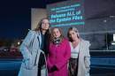 Annie Farmer, from left, Liz Stein and Danielle Bensky pose for a photo as a World Without Exploitation projection is seen on the wall of the National Gallery of Art calling on Congress to vote yes on the Epstein files transparency act in Washington, Monday, Nov. 17, 2025. (Jose Luis Magana/AP)