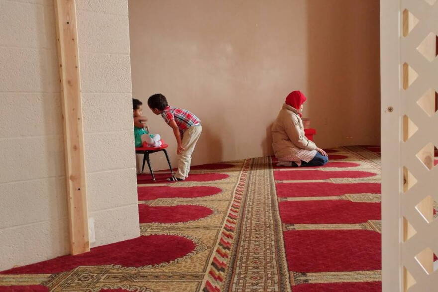 alia Mohamed prays before an interview at the Islamic Society of Columbus, Indiana, while her kids, 2-year-old Selma and 5-year-old Mohamed, play nearby.
