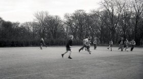 A group of schoolboys playing football outside on a large school playground, England, UK.