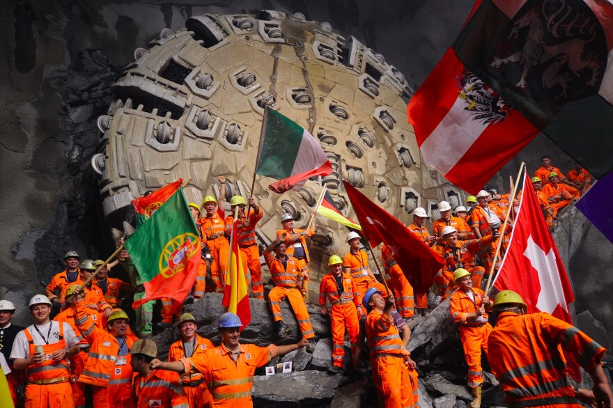 Miners celebrate beneath the Swiss Alps in 2010, after a giant drilling machine bored through to create the world's longest tunnel. After several more years of work, the train line through that tunnel is now open.