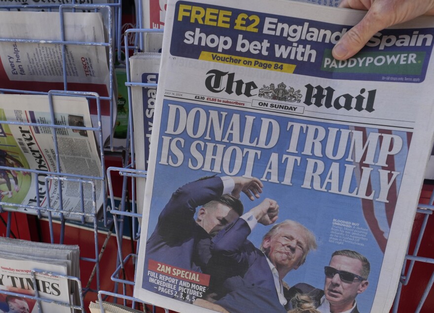 A woman buys a copy of the British Mail on Sunday newspaper at a newsagents in London, Sunday, July 14, 2024, showing the reaction to events at former President Trump's campaign rally in Butler, Pennsylvania. Donald Trump's campaign says he is "fine" after what law enforcement officials are treating as an assassination attempt during a rally in Butler, Pennsylvania. (AP Photo/Kirsty Wigglesworth)