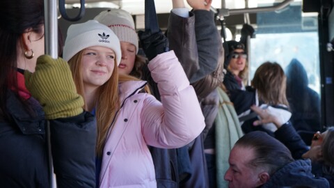 People wearing hats ride a bus.