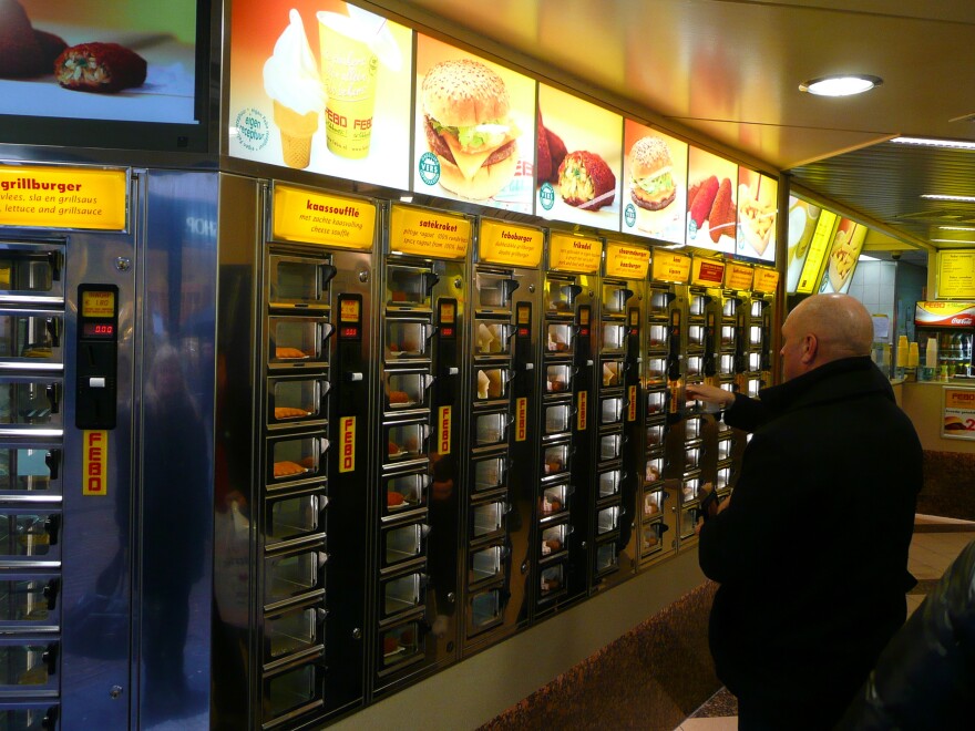 Customers choose from various hot foods available at one of Amsterdam's Febo vending machines.