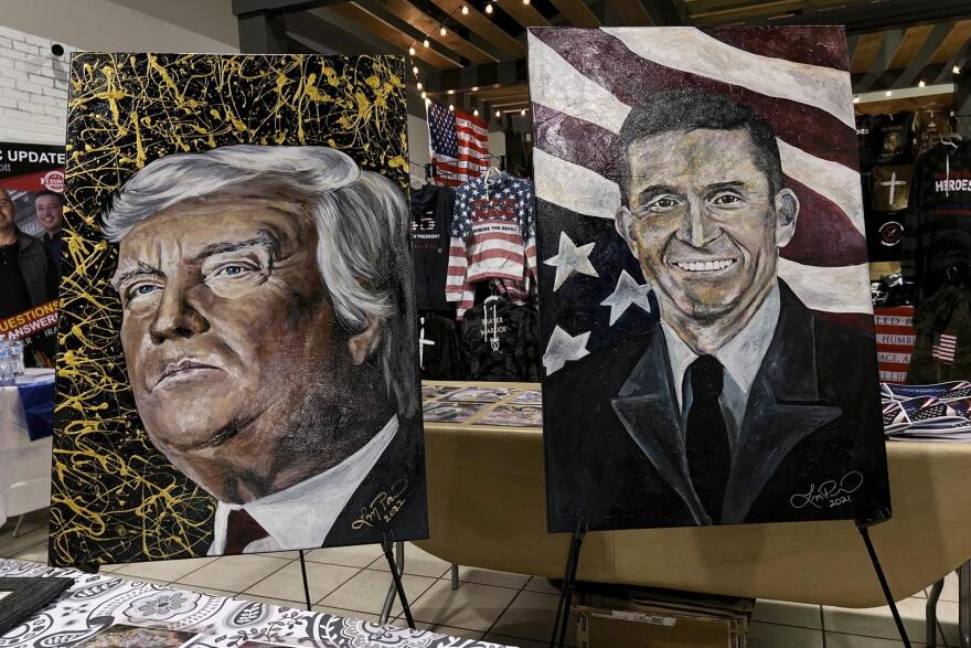 Paintings of former President Donald Trump and Michael Flynn, a retired three-star general who served as Trump's national security adviser, are displayed in a vendor area during the ReAwaken America tour at Cornerstone Church, in Batavia, N.Y., Friday, Aug. 12, 2022.