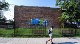 A boy walks to school past a mural in a fenced off and locked lot along Martin Luther King Jr. Avenue Southeat in the poorest ward of the city on July 23, 2010 in the Anacostia section of Washington.