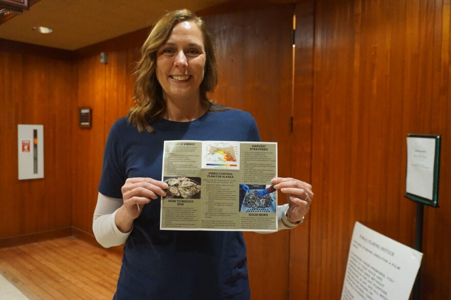 Shannon Boldt, a biologist with the Washington state-based Pacific Shellfish Institute, holds up a brochure on March 10. 2026, outlining the the risks of Vibrio parahaemolyticus infections and the steps that shellfish farmers can take to avoid them.