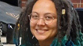  Young smiling person seated at audio console
