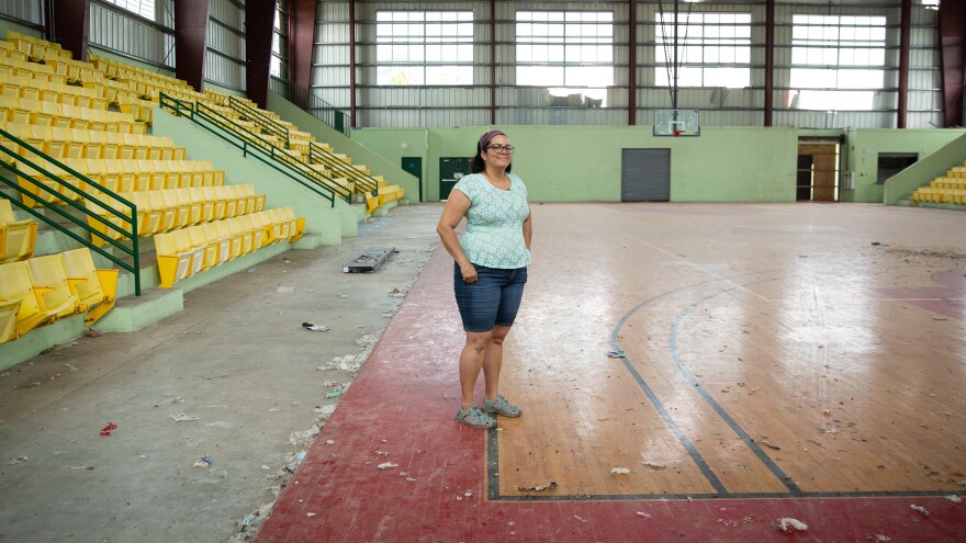 Elda Guadalupe Carrasquillo, a municipal legislator and a middle school science teacher in Vieques, Puerto Rico, stands on the island's only wooden basketball court. It was wrecked during Hurricane Maria. Since then, it's only been used by birds and roaming horses.