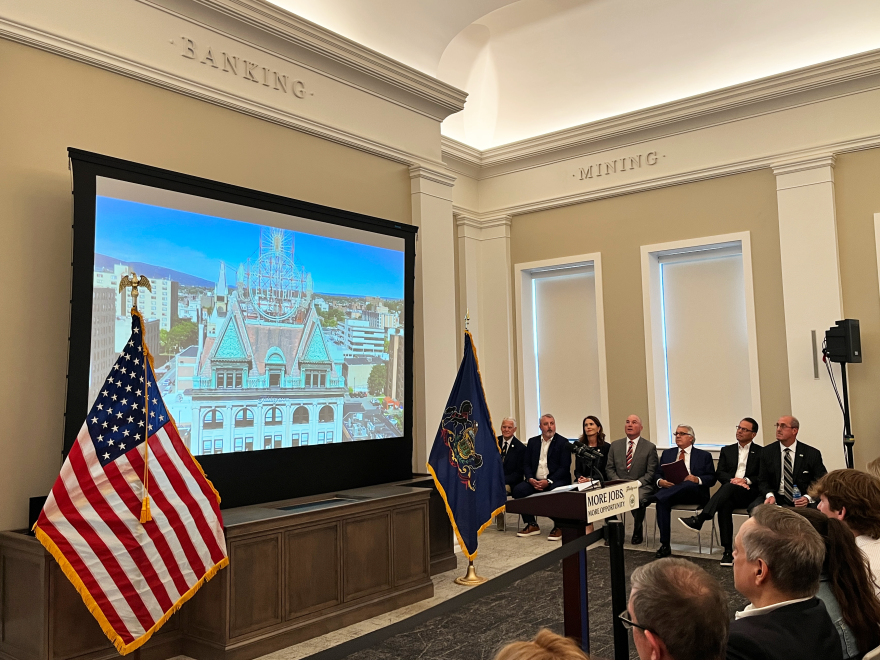 Lackawanna County Commissioner Thom Welby, left, state Rep. Kyle Donahue, state Rep. Bridget Kosierowski, state Sen. Marty Flynn, Brian Cali, chair of the Fidelity Bank Board of Directors; Governor Josh Shapiro and Daniel J. Santaniello, Fidelity Bank President and Chief Executive Officer, watch a video about the renovations to the Scranton Electric Building.
