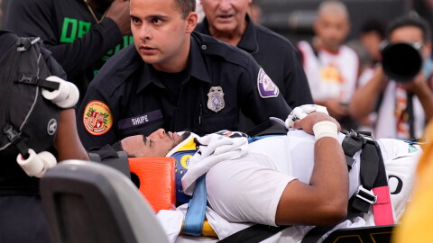 Oregon quarterback Dante Moore, bottom, is loaded into an ambulance following a hard tackle by Southern California linebacker Desman Stephens II during the first half of an NCAA college football game, Saturday, Sept. 26, 2026, in Los Angeles.
