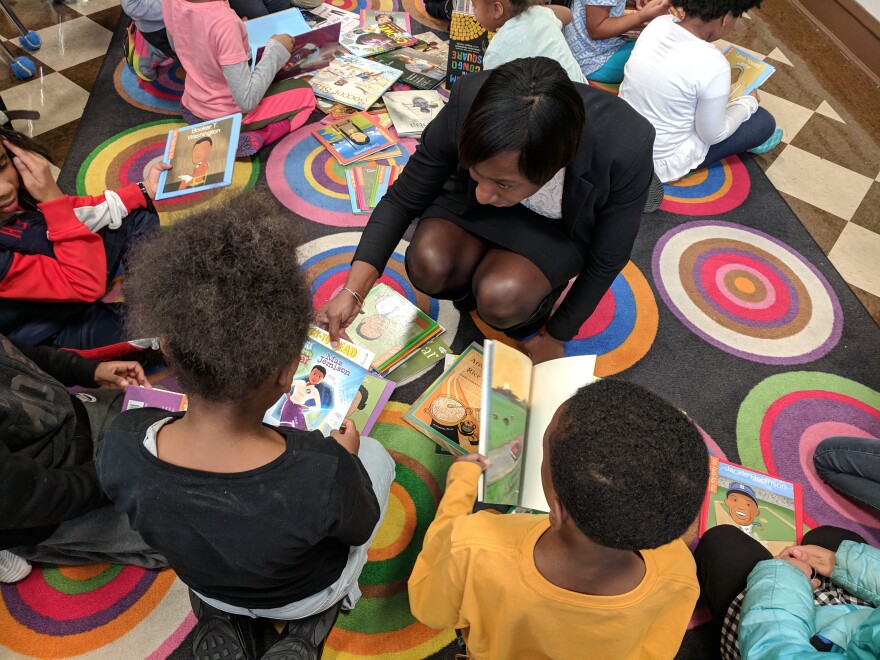 Woman handing books to kids