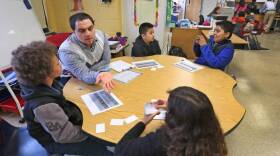 Fourth grade instructional aid Henry Velasquez works with students at Enlace Academy. More than half of the school's students are English learners.