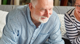 White text over a photo of an older couple smiling, reads: Donate Through Your IRA [DPM Logo]