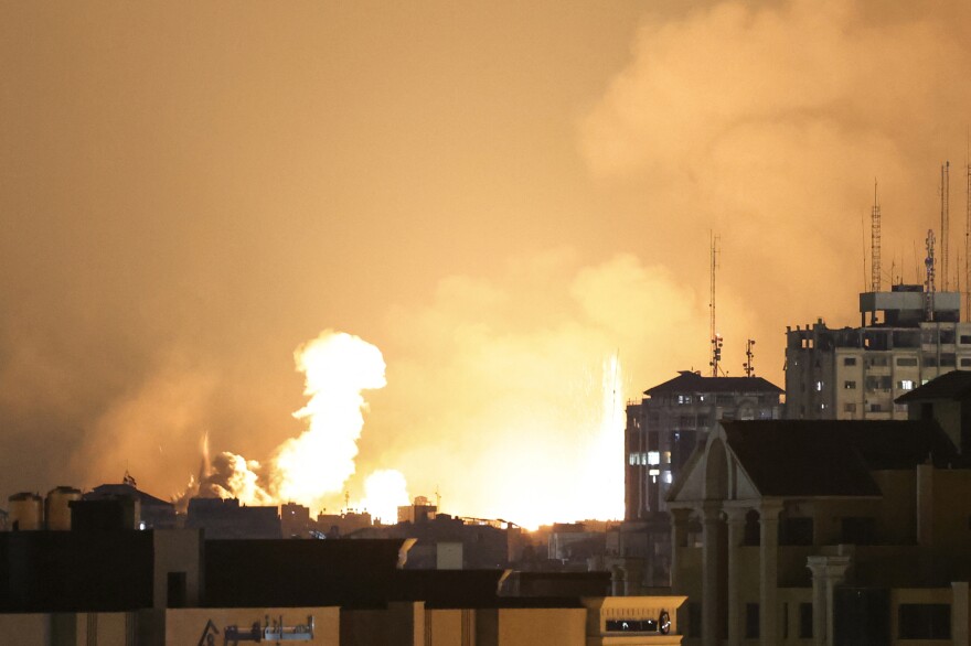 A plume of smoke rises above buildings in Gaza City during an Israeli air strike, on October 8, 2023.