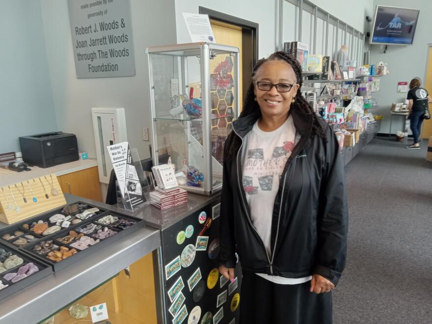 Mother's War on Violence host Yolanda Wallace with the Unsolved Murder Playing Cards in the Peoria Riverfront Museum gift shop.