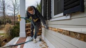 A Mass Save contractor blows insulation into a home in Holliston, Mass. (Miriam Wasser/WBUR)