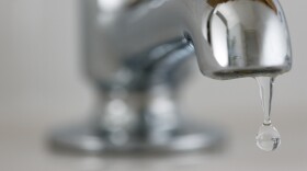 drop of water from a silver water faucet