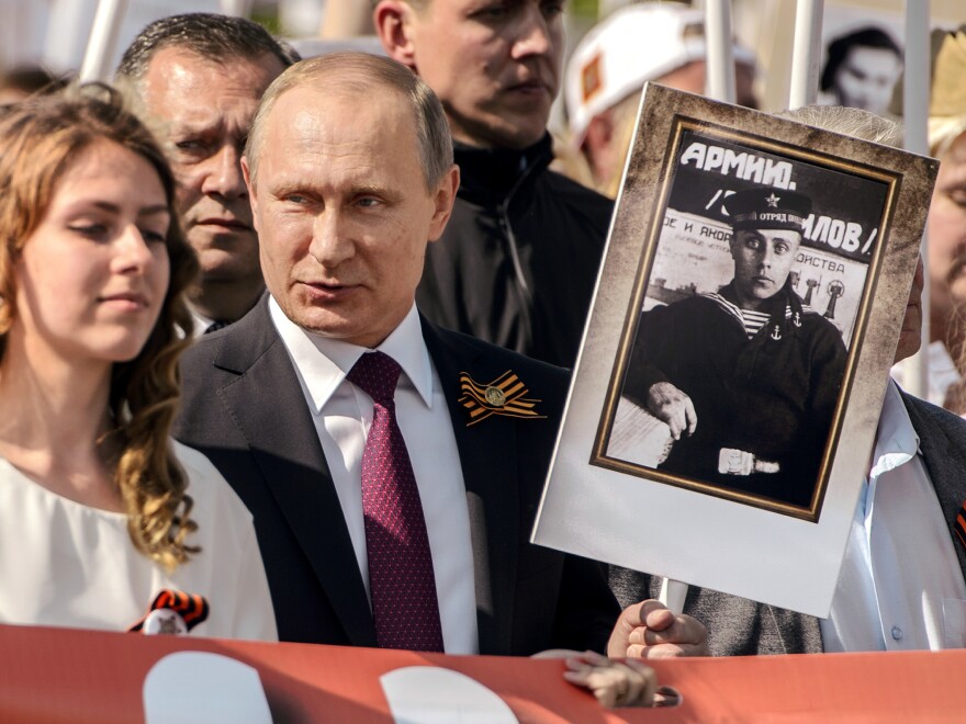 Russian President Vladimir Putin holds a portrait of his father, who fought in World War II, during Monday's Moscow parade marking Victory Day in Russia.