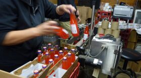 Bottles of Squamscot Soda get a label inside the company's factory in Newfields, N.H. (Todd Bookman/NHPR)