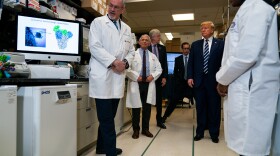 Deputy Director at the Vaccine Research Center at the National Institutes of Health, Dr. Barney Graham, speaks with President Donald Trump during a tour of the Viral Pathogenesis Laboratory at the National Institutes of Health, Tuesday, March 3, 2020, in Bethesda, Md. (AP Photo/Evan Vucci)