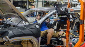 An FCA US employee uses a happy seat to install the right and left sun visors on a Jeep Cherokee at the Belvidere (Ill.) Assembly Plant. 