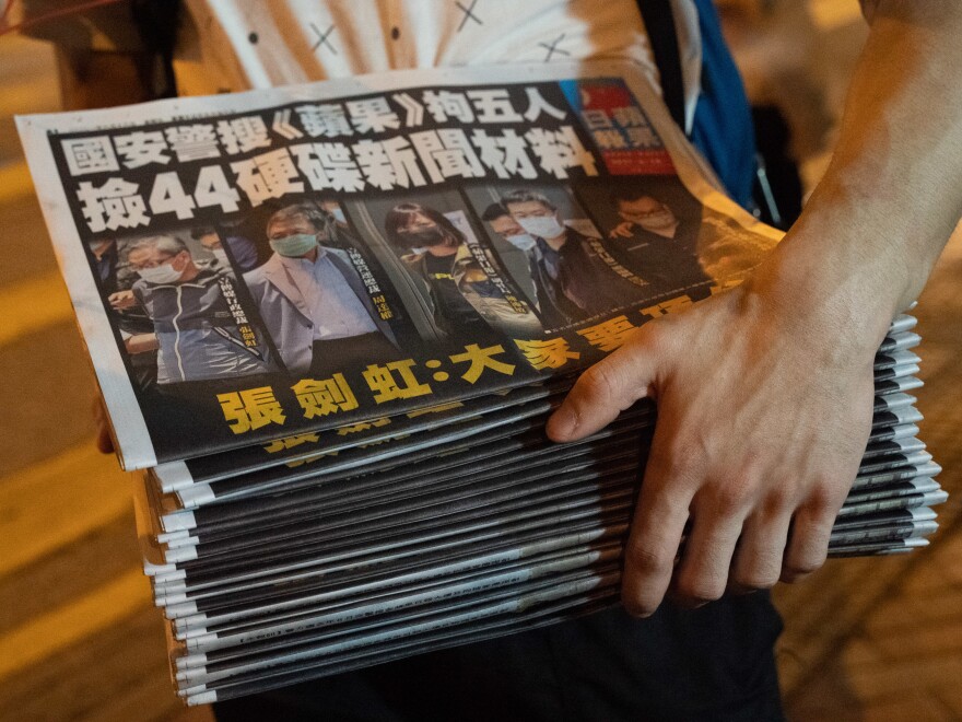 A man buys multiple copies of the latest Apple Daily newspaper in Hong Kong. Police raided the office of Apple Daily, the city's fierce pro-democracy newspaper, in an operation involving more than 200 officers. Secretary for Security John Lee said the company used "news coverage as a tool" to harm national security, according to local media reports.