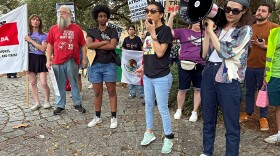 Participants at a rally and march hold up signs protesting President Donald Trump's appearance at Super Bowl 59 in New Orleans on Sunday, Feb. 9. 2025.